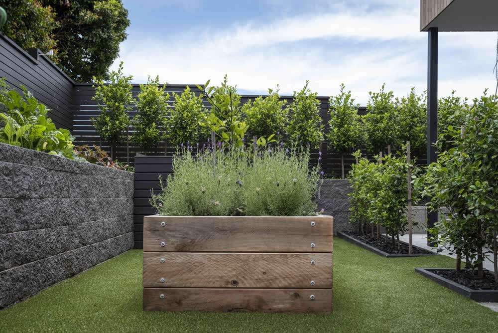Wooden planter boxes, retaining wall and black fencing